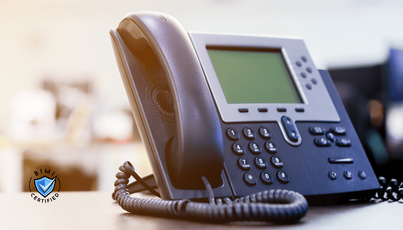 Moderní telefon na stole, který čeká na ověřovací hovor BIMI